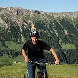 [Translate to Italiano:] Stefan auf seinem Mountain Bike auf der Seiser Alm bei den Dreharbeiten zum KONVERTO Video Smart Working